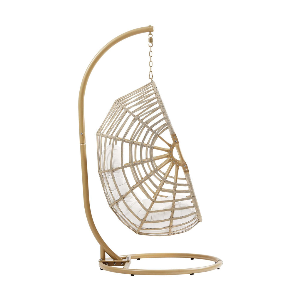 Outdoor hanging wicker swing chair with white cushion, curved frame and round woven basket.