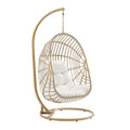 Outdoor hanging wicker swing chair with white cushion; arched rattan frame and chain.