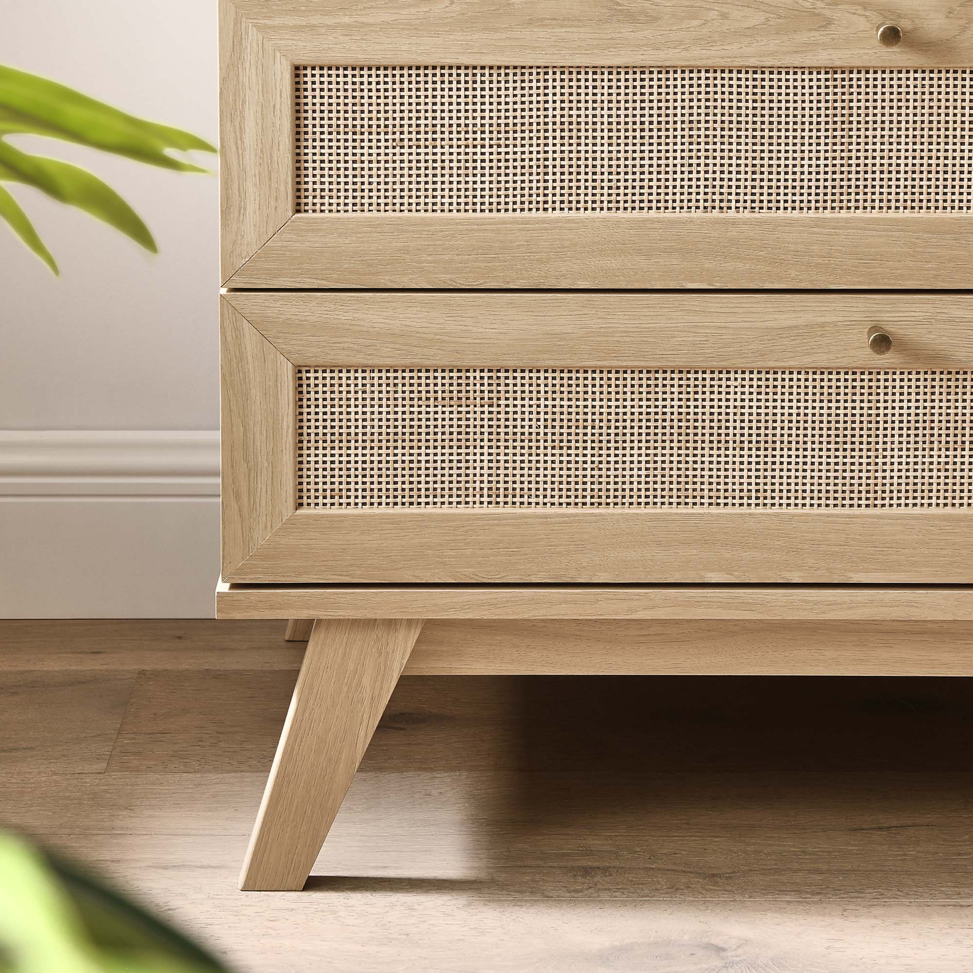 3-drawer wood dresser close-up with rattan drawer fronts and angled oak legs