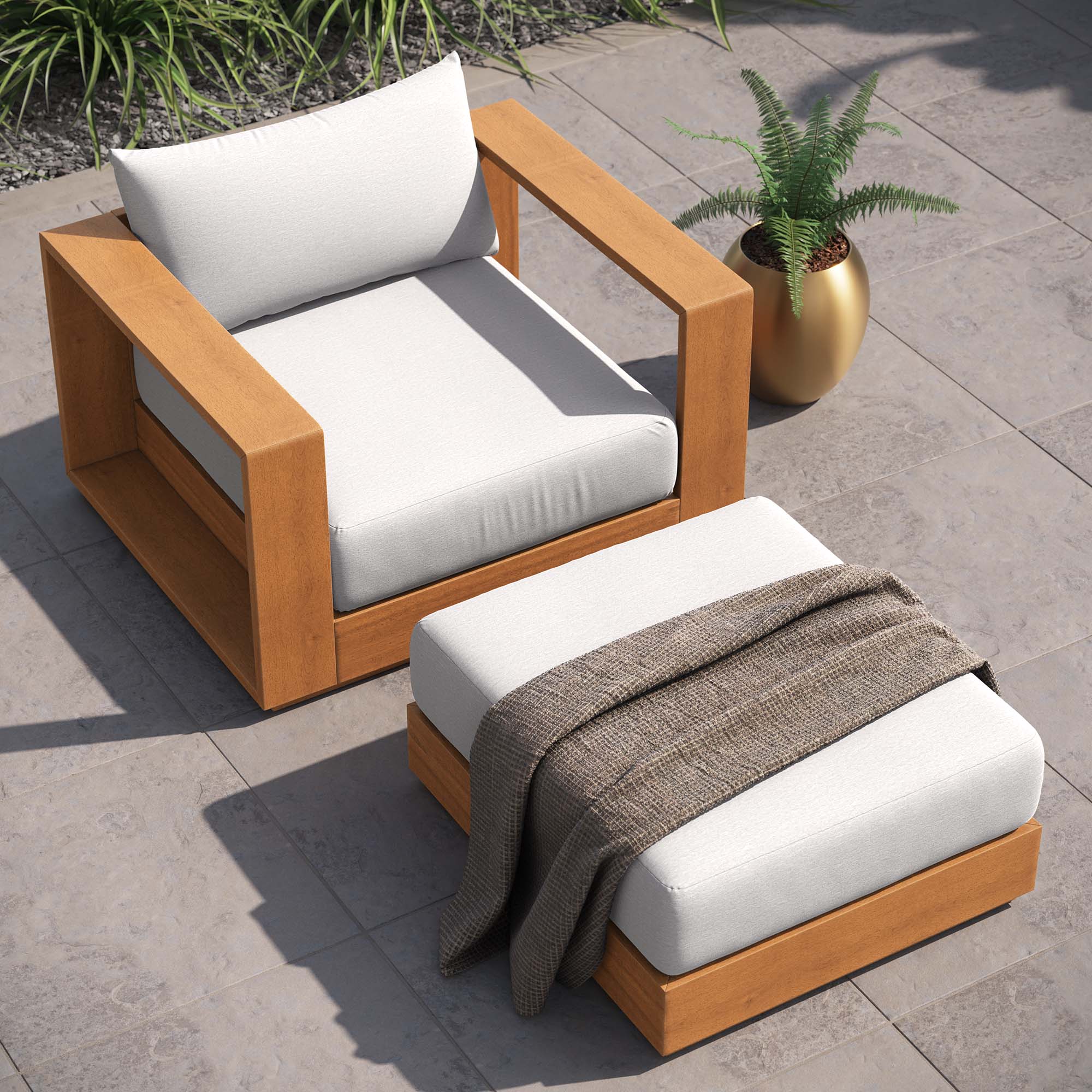 Outdoor acacia armchair with light gray cushions and matching ottoman, natural wood.