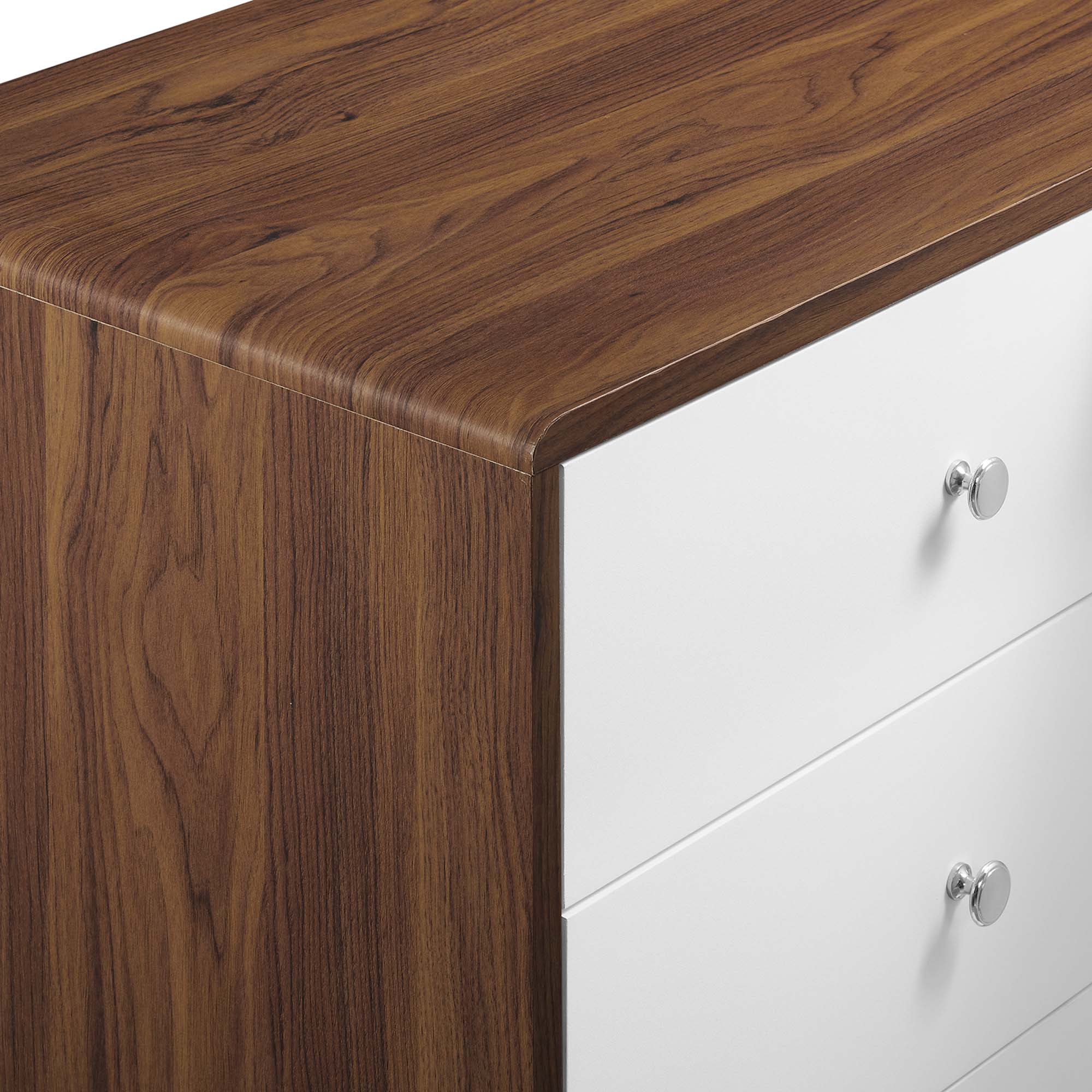 Wood side panel and white drawer fronts with round metal knobs on a dresser